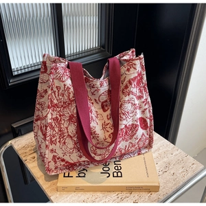 Detail of red Toile de Jouy canvas tote bag with wide reinforced woven shoulder straps