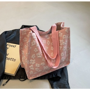 Detailed texture of pink canvas tote bag with 3D white flower embroidery pattern