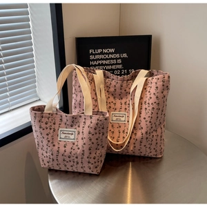 Détail comparant les petits et grands sacs fourre-tout en velours côtelé rose à fleurs