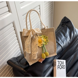 Vue détaillée du sac en toile de jute avec nœud en dentelle et pendentif fleuri