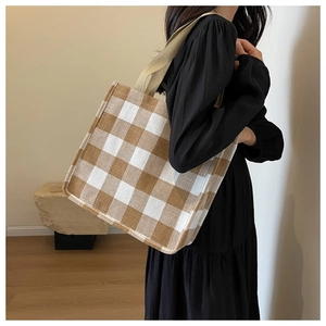 Détail du sac cabas en toile à carreaux montrant le tissu tissé et la bandoulière