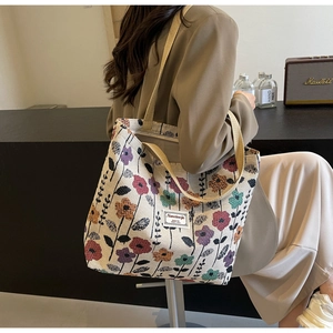 Detailed close-up of beige canvas tote bag with vintage floral pattern and sturdy handles