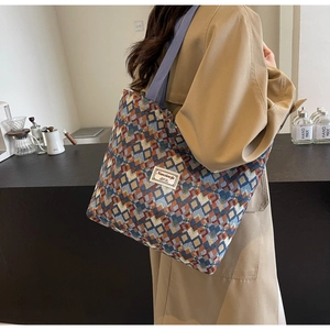 Detail of bohemian canvas tote bag with colorful geometric patterns and blue shoulder strap