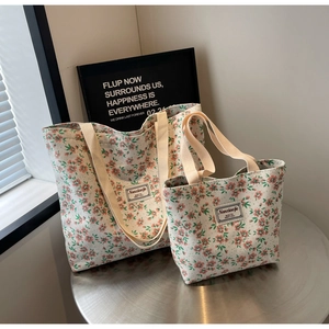 Gros plan de cabas en toile à fleurs de deux tailles avec texture de tissu détaillée