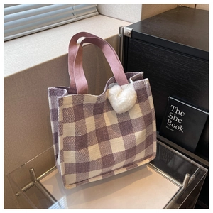 Détail du cabas à damier violet avec anses roses et pendentif coeur en peluche blanc