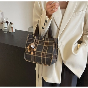 Dettaglio borsa shopper vintage a quadri con chiusura magnetica e ciondolo di peluche