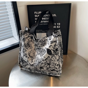 Detail of floral and butterfly print on large canvas tote bag with black strap