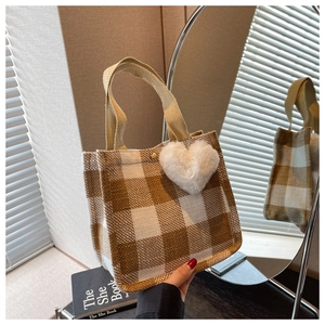 Détail du sac cabas en toile à carreaux marron avec un charme en forme de cœur