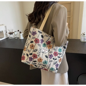 Close-up of floral jacquard tote bag featuring colorful woven patterns and beige straps