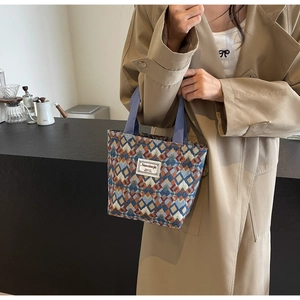 Detailed view of bohemian canvas tote bag with geometric pattern and woven purple handles