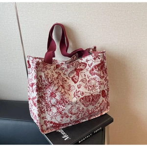 Detail of floral canvas tote bag featuring butterfly patterns on a vintage book