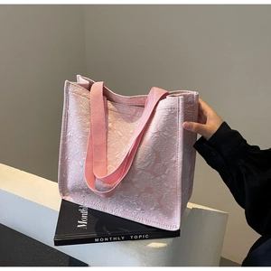 Détail du cabas rose en jacquard floral avec texture tissée premium et bandoulière robuste