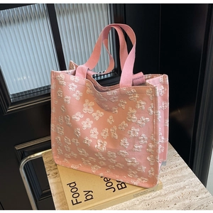Detail of pink canvas tote bag with 3D white floral patterns and woven handles