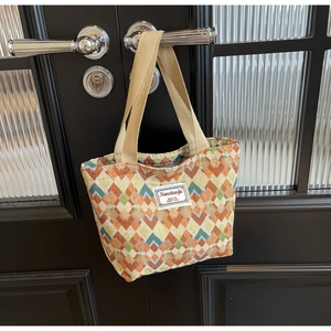 Detail of bohemian geometric tote bag showing colorful jacquard texture and canvas handle