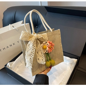 Détail du sac en toile avec nœud en dentelle et pendentif fleur fait à la main