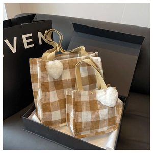 Détails de sacs cabas à carreaux dans un coffret avec breloques cœur et poignées en toile