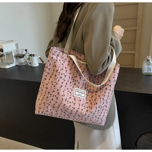 Gros plan du sac cabas en velours côtelé rose avec imprimé fleuri et texture douce