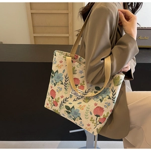 Close-up of floral jacquard canvas tote bag with woven patterns and decorative label