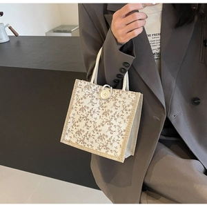 Dettaglio della borsa floreale in tela con manici in corda e chiusura con bottone