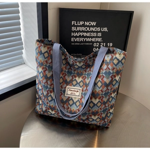 Close-up of geometric jacquard pattern and woven strap on a large canvas tote bag