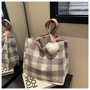 Détail du sac cabas à carreaux avec anses roses et breloque cœur en peluche blanche
