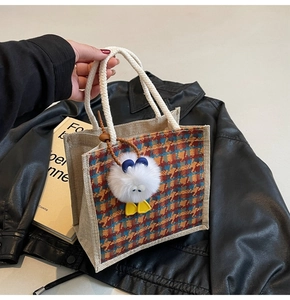 Linen tote bag detail with colorful plaid pattern and cute plush monster charm