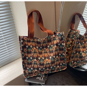 Detailed close-up of bohemian knit tote bag with geometric rhombus pattern and woven handles