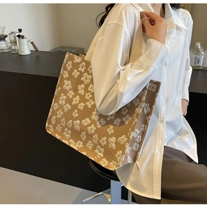 Detail of large brown tote bag with 3D cream floral texture on durable canvas fabric