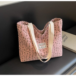 Détail du cabas en velours côtelé rose à fleurs avec larges anses crème et écusson