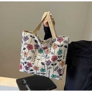 Detail shot of the vintage canvas tote bag showing floral patterns and woven brand label