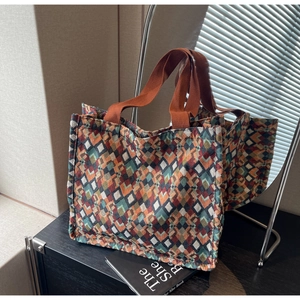 Detailed view of colorful geometric woven tote bag with durable orange ribbon handles