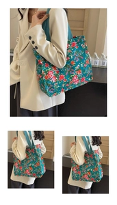 Close-up of green floral canvas tote bag with red rose pattern and wide shoulder straps