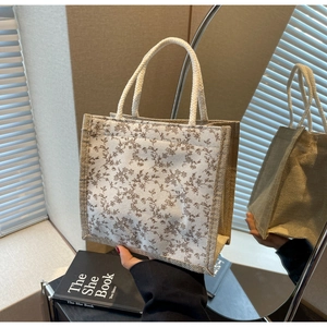 Dettaglio borsa tote in lino floreale beige con manici in corda intrecciata e stampa retrò