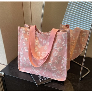 Detail of pink tote bag with 3D floral texture and sturdy pink woven handles