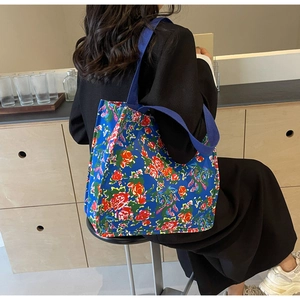 Detail of floral tote bag showing wide shoulder strap and vintage flower patterns