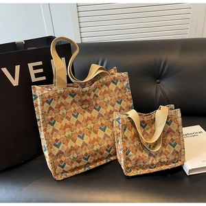 Detail of woven tote bag set with vibrant geometric diamond patterns and canvas straps