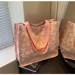Detailed close-up of pink tote bag with 3D floral embroidery and wide ribbon handle