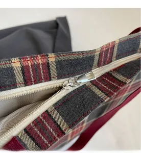 Close-up of smooth nylon zipper and classic plaid pattern on canvas tote bag