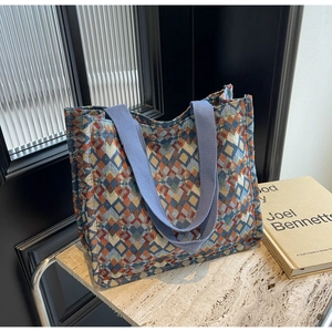 Detailed view of bohemian tote bag with colorful geometric woven fabric and purple handles