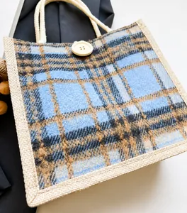 Nahaufnahme der blau-braun karierten Leinentasche mit Holzknopf und rustikalem Griff