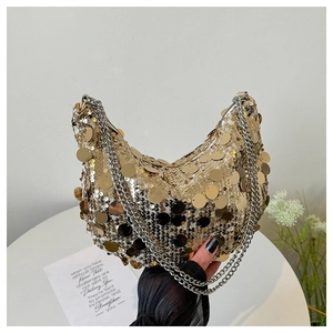 Détail d'un sac demi-lune doré à paillettes brillantes avec une fine bandoulière chaîne