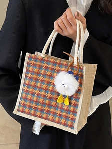 Linen tote bag featuring a colorful houndstooth pattern and a cute plush monster charm