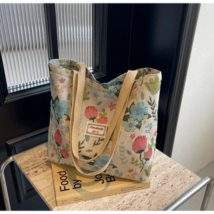 Detailed view of large canvas tote bag with floral tulip patterns and sturdy handles