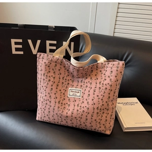 Détail du sac cabas en velours côtelé fleuri avec étiquette et anses en toile