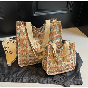 Detail of bohemian geometric woven tote bags in two sizes with colorful canvas textures