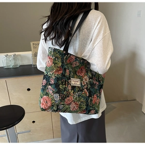 Detailed close-up of a floral tapestry tote bag with rose patterns and a black strap