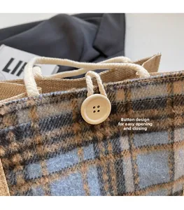 Detail der blau-braun karierten Leinentasche mit Knopfverschluss und strukturierter Optik