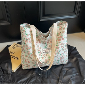 Détail du cabas en velours côtelé blanc avec imprimé floral rose et étiquette tissée