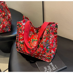 Detail of red floral tote bag with traditional Chinese peony patterns on a black chair