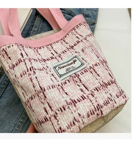 Detail of pink and white tweed tote bag featuring woven linen base and fabric label